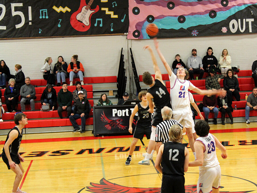 At tipoff against Klahowya, EJ center Stuart Dow (#21) leaps high while teammate Aidan Stepanski (#23) stands ready to receive the ball. Photo by Jeremy Botkin